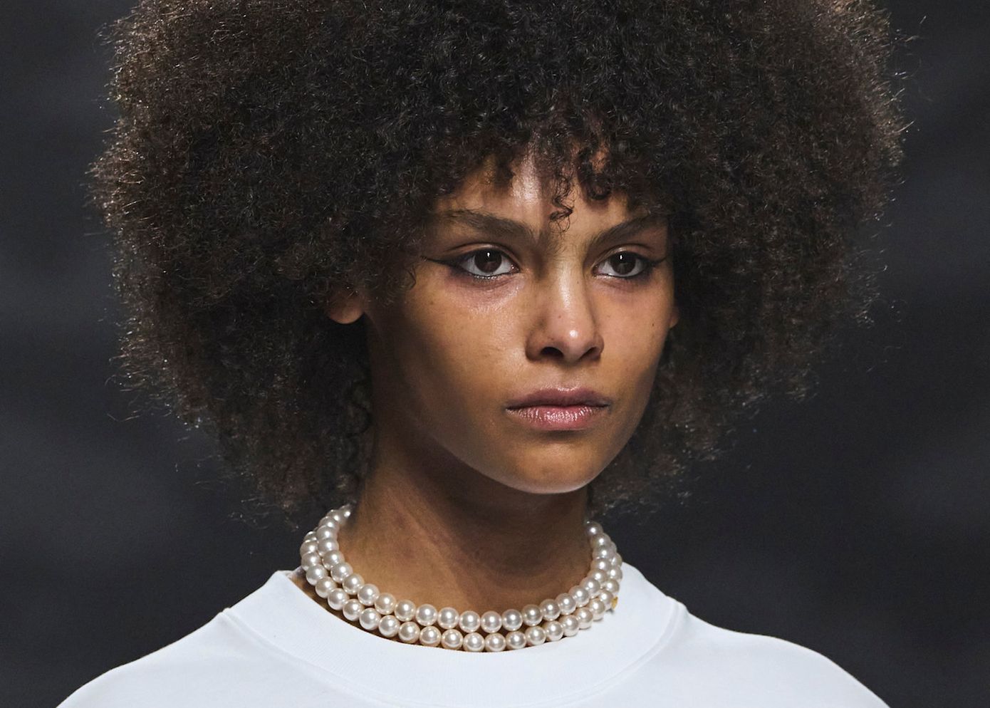 Γυναίκα εφαρμόζει λιπαντικό σε σγουρά μαλλιά