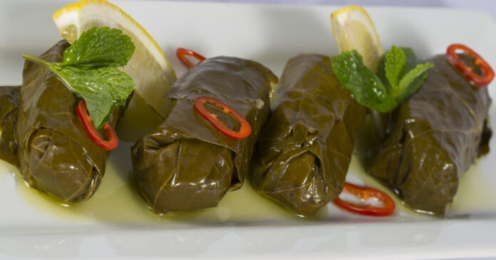 Πιάτο με ντολμάδες με μπακαλιάρο σερβιρισμένους με σάλτσα αυγολέμονο